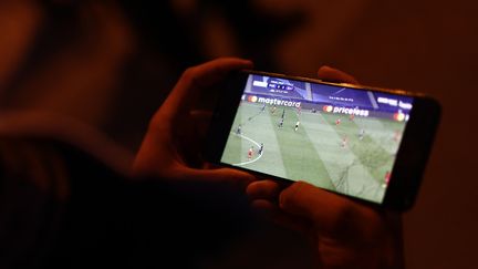 Un match de football en streaming sur un smartphone (SAMEER AL-DOUMY / AFP)