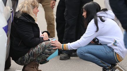 Une femme adossée à une voiture de police après l'attaque au couteau de Nice, le 29 octobre 2020. (VALERY HACHE / AFP)