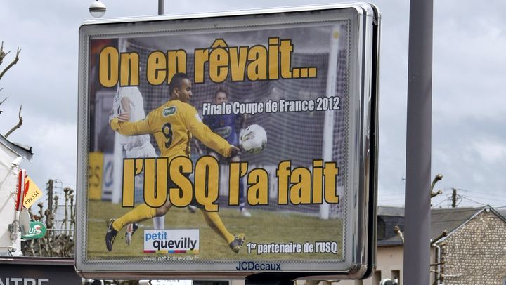 Partout dans Quevilly fleurissent des affiches &agrave; la gloire des h&eacute;ros de la Coupe de France.&nbsp; (CHARLY TRIBALLEAU / AFP)