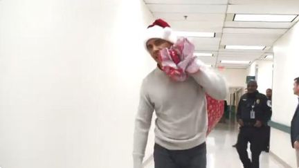 Capture d'écran de la vidéo postée sur Twitter montrant Barack Obama distribuer des cadeaux&nbsp;à des enfants malades, dans un hôpital de Washington (Etats-Unis), mercredi 19 décembre 2018. (CHILDREN'S NATIONAL)