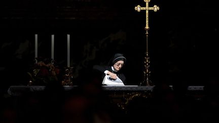 Une nonne repasse sur un autel avant l'arriv&eacute;e du pape Beno&icirc;t XVI pour c&eacute;l&eacute;brer le dimanche de Pentec&ocirc;te &agrave; la basilique Saint-Pierre de Rome (Italie), le 27 mai 2012. (FILIPPO MONTEFORTE / AFP)