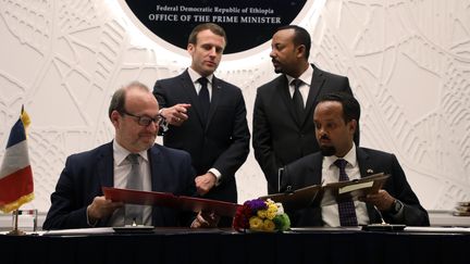 Le président français Emmanuel Macron, le Premier ministre éthiopien Abiy Ahmed (en haut), le directeur de l'Agence française de développement Rémy Rioux et le ministre éthiopien des Finances Ahmed Shide signent un accord de coopération à Addis Abeba, le 12 mars 2019. (Ludovic MARIN / POOL / AFP)