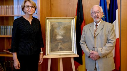 Peter Forner, et l'Ambassadrice de France en Allemagne, Anne-Marie Descôtes entourent le tableau de Nicolas Rousseau.&nbsp; (BRITTA PEDERSEN / DPA)