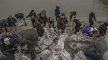 Des habitants remplissent des sacs de sable pour former des barricades le long des plages d'Odessa (Ukraine), face à la mer Noire, lundi 7 mars 2022. (BULENT KILIC / AFP)