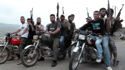 Des membres de l'Arm&eacute;e syrienne libre posent sur leurs motos dans la banlieue de Homs (Syrie), le 28 juin 2012. (DJILALI BELAID / AFP)