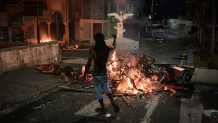 Un manifestant devant un barrage enflammée au Gosier (Guadeloupe), le 20 novembre 2021. (MAXPPP)