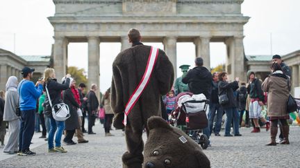 Un homme en costume d'ours se tient devant la porte de Brandebourg &agrave; Berlin (Allemagne), le 17 octobre 2013. (OLE SPATA / DPA / AFP)