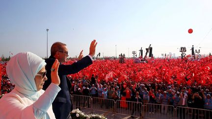 Le président Recep Tayyip Erdogan et son épouse, Emine Gulbaran, saluent la foule lors du rassemblement géant «pour la démocratie et les martyrs», organisé par l’AKP, Parti de la justice et du développement au pouvoir. Ce rassemblement a marqué l'apothéose de trois semaines de mobilisation dans les rues après le putsch raté du 15 juillet en Turquie. Il s'est transformé en démonstration de force pour le président Erdogan. Prenant la parole à la fin de la manifestation, ce dernier a de nouveau évoqué un possible rétablissement de la peine de mort en Turquie. «Si le peuple veut la peine de mort, les partis suivront sa volonté», a-t-il dit devant ses sympathisants qui scandaient «peine de mort!». Le chef d'état-major Hulusi Akar, brièvement enlevé par les putschistes, a été acclamé en héros par la foule. Il a lui aussi été interrompu par des cris de «peine de mort!». Un rétablissement de la peine capitale abolie en 2004 sonnerait le glas des négociations, déjà très compromises, d'adhésion de la Turquie à l'Union européenne. (Reuters - Presidential Palace - Kayhan Ozer)