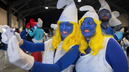 Des femmes déguisées en schtroumpfettes participent, le 25 mars 2023, à un rassemblement de schtroumpfs organisé à Landerneau, dans l'ouest de la France, en vue d'établir un record mondial. (FRED TANNEAU / AFP)