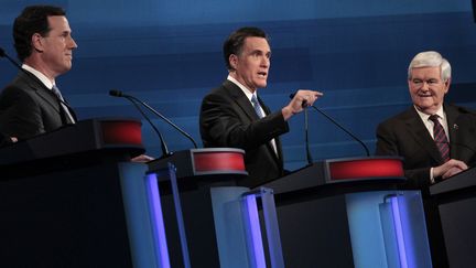 Les candidats &agrave; l'investiture r&eacute;publicaine Rick Santorum (&agrave; g.) et Newt Gingrich (&agrave; dr.) &eacute;coutent Mitt Romney s'exprimer lors d'un d&eacute;bat t&eacute;l&eacute;vis&eacute; pr&eacute;c&eacute;dant la primaire en Caroline du Sud, le 16 janvier 2012 &agrave; Myrtle Beach (Etats-Unis). (CHARLES DHARAPAL / REUTERS)