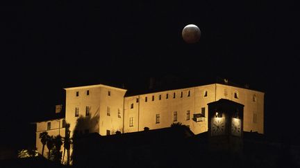 Le&nbsp;"Castello della Manta", à Manta (Italie), et la lune, le 21 janvier 2019. (MARCO BERTORELLO / AFP)