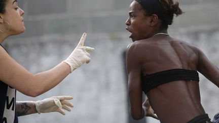 Une agente municipale (G) tente de raisonner une "crack addict" lors d'une op&eacute;ration anti-drogue &agrave; Rio de Janeiro (Br&eacute;sil), le 17 octobre 2012. (RICARDO MORAES / REUTERS)