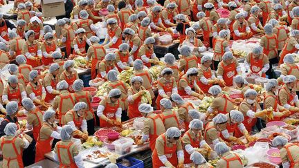 Comme chaque ann&eacute;e, pr&egrave;s de 2 000 femmes cor&eacute;ennes pr&eacute;parent 270 tonnes de kimchi, un plat traditionnel qui sera distribu&eacute; &agrave; l'occasion d'un repas destin&eacute; aux n&eacute;cessiteux &agrave; S&eacute;oul (Cor&eacute;e du sud), le 8 novembre 2012. (JO YONG-HAK / REUTERS)