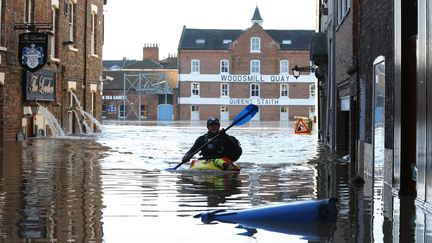 Un homme utilise un canoë dans les rues inondées de York (Royaume-Uni), le 27 décembre 2015. (LINDSEY PARNABY / ANADOLU AGENCY / AFP)