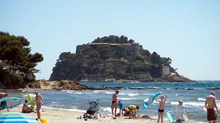 Des personnes sur la plage de Cabasson (Var) et le Fort de Brégançon en arrière-plan. (BERTRAND LANGLOIS / AFP)