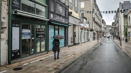 Une passante sous la pluie, à Pau (Pyrénées-Atlantiques), le 25 janvier 2022. (QUENTIN TOP / HANS LUCAS / AFP)