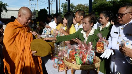 Des personnes déposent des offrandes devant un moine bouddhiste, le 13 octobre 2018, dans la province de&nbsp;Narathiwat en Thaïlande. (MADAREE TOHLALA / AFP)