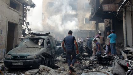 Des habitants d'Idlib (Syrie) inspectent les débris d'un bâtiment détruit par des bombardements du régime syrien, le 10 septembre 2016. (ABDURRAHMAN SAYID / ANADOLU AGENCY / AFP)