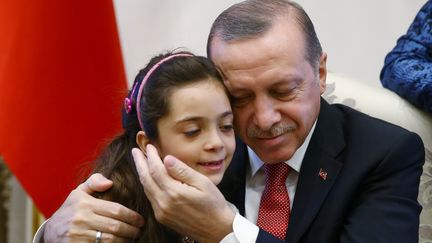 Le président turc, Recep Tayyip Erdogan, enlace la petite Bana Al-Abed, évacuée d'Alep-Est il y a une semaine, le 21 décembre 2016, à Ankara (Turquie).&nbsp; (KAYHAN OZER / REUTERS)