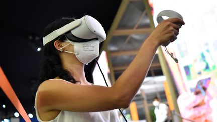 Une femme essaye des lunettes de réalité virtuelle au Mobile world congress de Barcelone, en juin 2021. (PAU BARRENA / AFP)