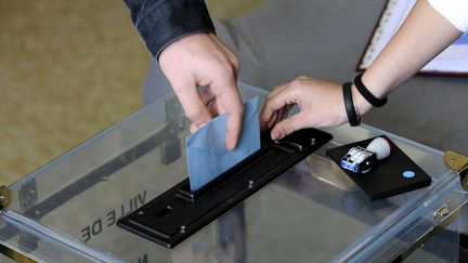 Un &eacute;lecteur glisse son bulletin de vote dans l'urne en 2012 pour l'&eacute;lection pr&eacute;sidentielle. (ALAIN LE BOT / PHOTONONSTOP / AFP)