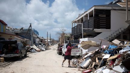 Un&nbsp;habitant de Saint-Martin déblaie les décombres de sa maison à&nbsp;Grand-Case, le 12 septembre 2017, après le passage de l'ouragan Irma sur l'île. (MARTIN BUREAU / AFP)