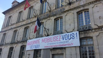 Une banderole installée sur la façade de la mairie de Bernay, dans l'Eure, en mars 2018, pour défendre la petite maternité de la commune, menacée de fermeture. (ARIANE GRIESSEL / FRANCEINFO)