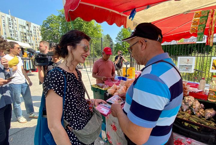 New Popular Front candidate Sabrina Ali Benali exchanges with a man on a market in Montreuil (Seine-Saint-Denis), June 26, 2024. (MATHILDE GOUPIL / FRANCEINFO)