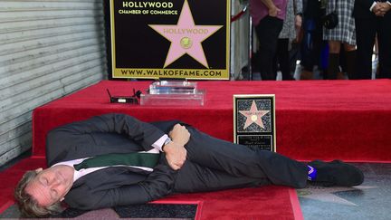 Hugh Laurie allongé près de son étoile sur le Hollywood Walk of Fame
 (Frederic J. Brown / AFP)