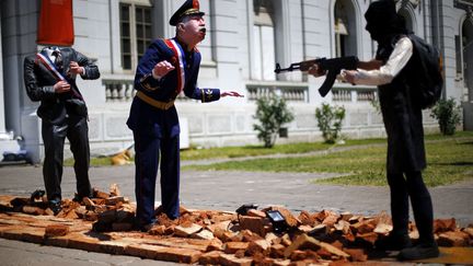 Une sculpture repr&eacute;sentant l'ancien dictateur chilien Augusto Pinochet (C) bless&eacute; par un &eacute;tudiant arm&eacute; est expos&eacute;e au mus&eacute;e d'art contemporain de Santiago (Chili), le 2 d&eacute;cembre 2014. (IVAN ALVARO / REUTERS)