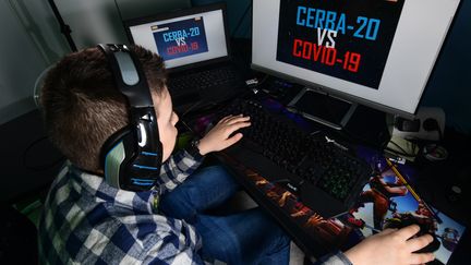 Lupo Daturi devant le jeu vidéo "Cerba-20" qu'il a créé pour tromper l'ennui pendant le confinement le 24 avril 2020 à Binasco (Italie). (MIGUEL MEDINA / AFP)