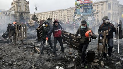 Pendant ce temps, des opposants au gouvernement d&eacute;placent des palettes de bois pour pr&eacute;parer leurs nouvelles prises de&nbsp;position. (LOUISA GOULIAMAKI / AFP)