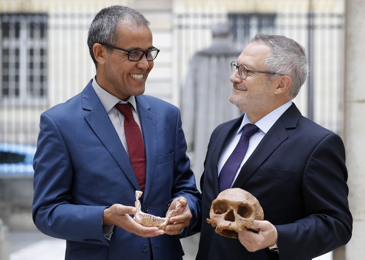 Le professeur&nbsp;Abdelouahed Ben-Ncer (à gauche), de l'Institut national marocain d’archéologie et du patrimoine (Maroc), et Jean-Jacques Hublin, montrent des éléments (moulés) du crâne d'un Homo sapiens découvert à Djebel Irhoud (ouest du Maroc). Photo prise à Paris le 6 juin 2017. (PATRICK KOVARIK / AFP)