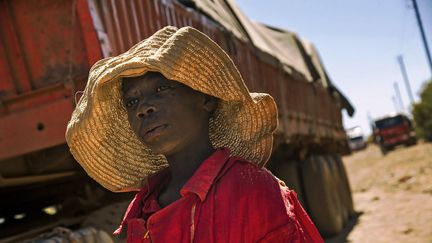 Un enfant congolais devant un camion transportant des roches extraites d'une mine de cobalt à Lubumbashi, au sud de la RDC, en mai 2016.&nbsp; (JUNIOR KANNAH / AFP)