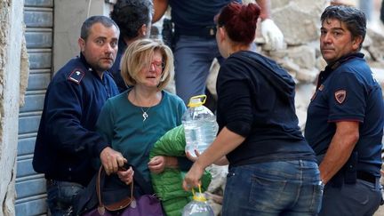 Une femme, en pleurs, après avoir été secourue à Amatrice (REMO CASILLI / REUTERS / X02874)