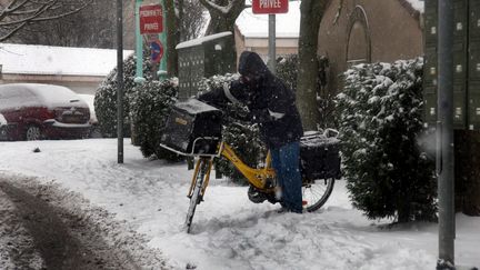 Un postier à vélo travaille sous la neige à Thionville (Lorraine), en décembre 2009. (PELAEZ JULIO / MAXPPP)