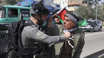 Un soldat de l'armée israélienne face à un manifestant palestinien dans le village d'Huwara, en Cisojordanie occupée, le 3 mars 2023. (JAAFAR ASHTIYEH / AFP)