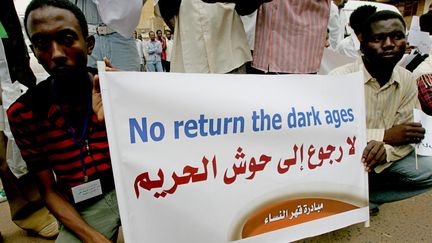 Une banderole dénonçant les lois répressives à l'égard des femmes lors d'une mobilisation&nbsp;devant&nbsp;le tribunal de Khartoum, la capitale soudanaise, le 4 août 2009.&nbsp;&nbsp; (ASHRAF SHAZLY / AFP)