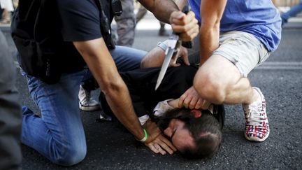 Des personnes ma&icirc;trisent un juif ultra-orthodoxe lors de la Gay Pride de J&eacute;rusalem, le 30 juillet 2015. (AMIR COHEN / REUTERS)