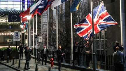 Le drapeau britannique est retiré par des employés, devant le Parlement européen à Bruxelles (Belgique), le 31 janvier 2020. (ARIS OIKONOMOU / AFP)