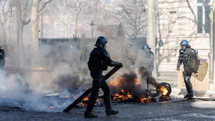 Un gendarme démantèle une barricade lors de la 18e journée de mobilisation des "gilets jaunes" à Paris, samedi 16 mars 2019.&nbsp; (JONATHAN PHILIPPE LEVY / HANS LUCAS)