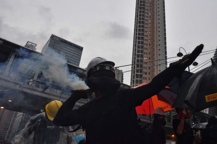 Un manifestant lance un projectile en direction des forces de l'ordre à Hong Kong, le 25 août 2019. (LILLIAN SUWANRUMPHA / AFP)