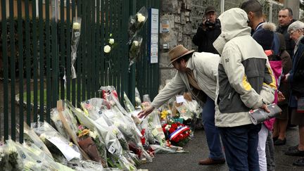 Des personnes viennent rendre hommage au gendarme Arnaud Beltrame, samedi 24 mars 2018 à Trèbes (Aude). (MAXPPP)