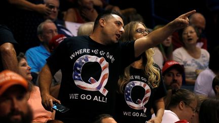 Des partisans de Donald Trump rêvetus d'un t-shirt affichant la lettre Q et le slogan du mouvement QAnon "Où l'un d'entre nous va, nous y allons tous"&nbsp;avant la prise de parole du président américain Donald Trump lors d'un meeting à Wilkes-Barre en Pennsylvanie (Etats-Unis) le 2 août 2018. (LEAH MILLIS / REUTERS)