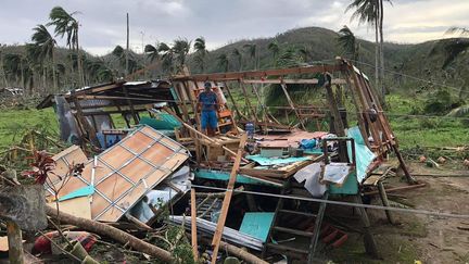 Un habitant de l'île de Siargao (Philippines) tente de sauver ce qu'il reste de sa maison, soufflée par le typhon Rai le 16 décembre 2021. (ROEL CATOTO / AFP)