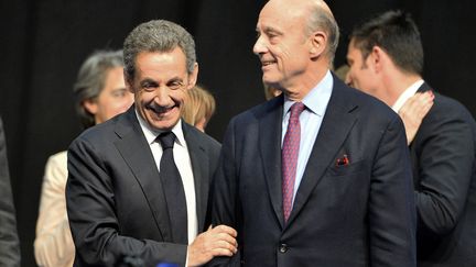 L'ancien président Nicolas Sarkozy et le maire de Bordeaux, Alain Juppé, lors d'un meeting de campagne à Limoges, le 14 octobre 2015. (NICOLAS TUCAT / AFP)