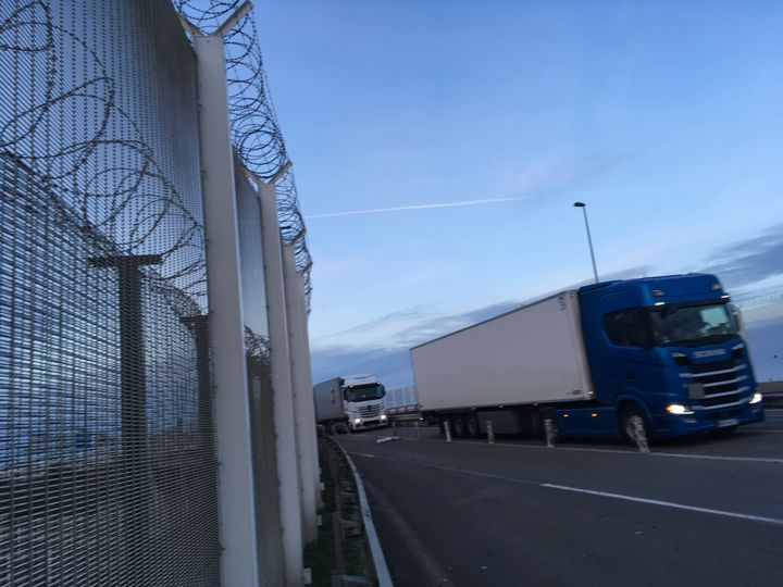 Des barbelés encerclent la route pour empêcher les migrants d'accéder aux camions, avant que ces derniers n'embarquent sur les ferries. (GREGOIRE LECALOT / RADIO FRANCE)