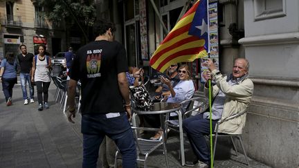 A Barcelone (Espagne), un homme agite l'Estalada, symbole de l'ind&eacute;pendance catalane, dimanche 27 septembre 2015. (ANDREA COMAS / REUTERS)