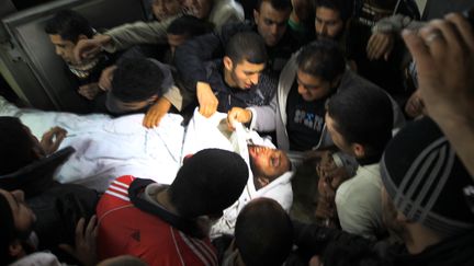 Des palestiniens portent le corps d'une victime &agrave; la morgue de l'h&ocirc;pital al-Shifa &agrave; Gaza le 9 mars 2012. (MAHMUD HAMS / AFP)