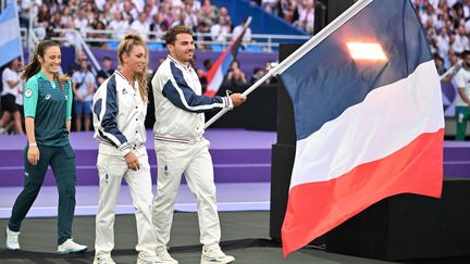 Les porte-drapeaux font leur entrée sur le stade. Antoine Dupont et Pauline Ferrand-Prévôt, tous les deux titrés pendant ces Jeux de Paris 2024, représentent la délégation française. (KMSP / AFP)